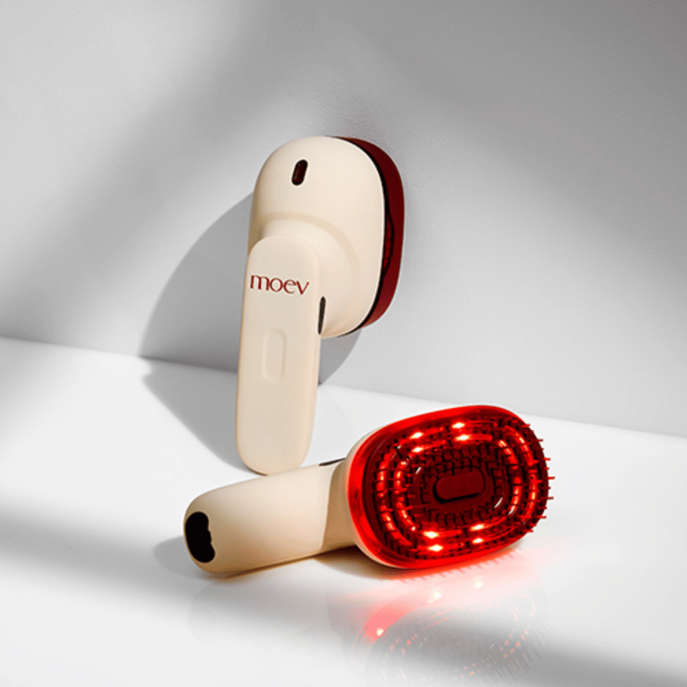 Dos MOEV Hair Steamer Pro sobre fondo blanco. Uno muestra luces LED rojas activadas que estimulan el cuero cabelludo y mejoran el crecimiento del cabello.