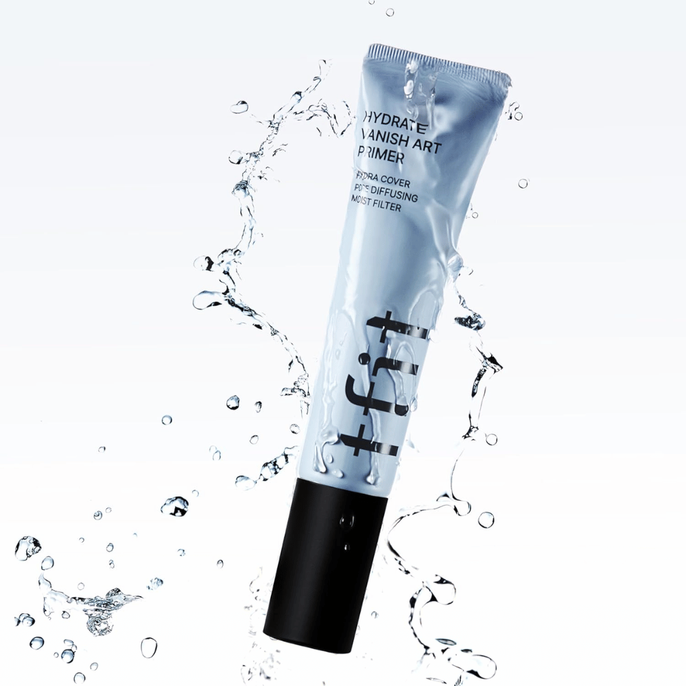 TFIT Hydrate Vanish Art Primer en tubo azul rodeado de agua salpicante, lo que simboliza las propiedades hidratantes del producto y la sensación fresca al aplicarlo.
