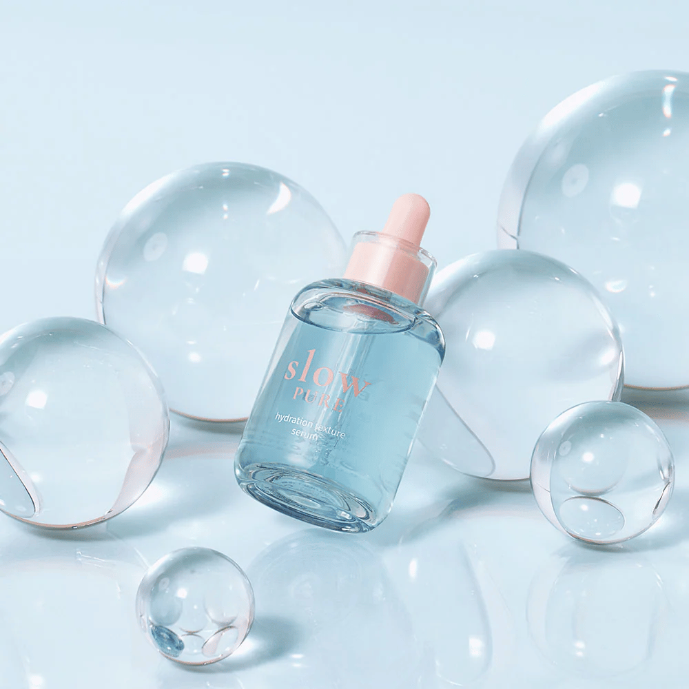 Slow Pure Hydration Texture Serum colocada entre burbujas transparentes, símbolo de hidratación intensa.