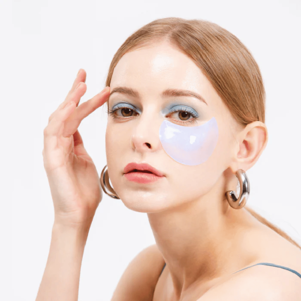 Modelo lleva un parche de hidrogel azul brillante bajo el ojo para efecto refrescante.