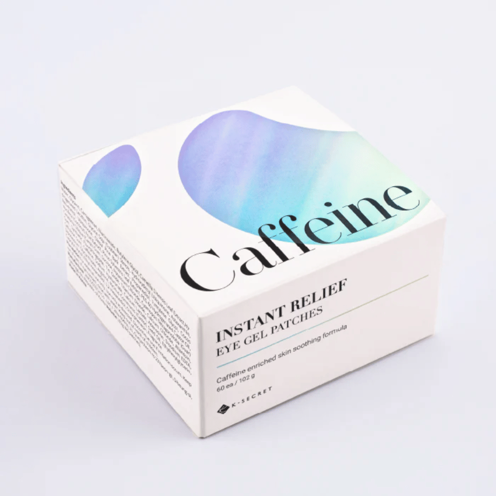 Empaque de K-Secret Instant Relief Eye Gel Patches con cafeína en diseño blanco con tonos azules y verdes.