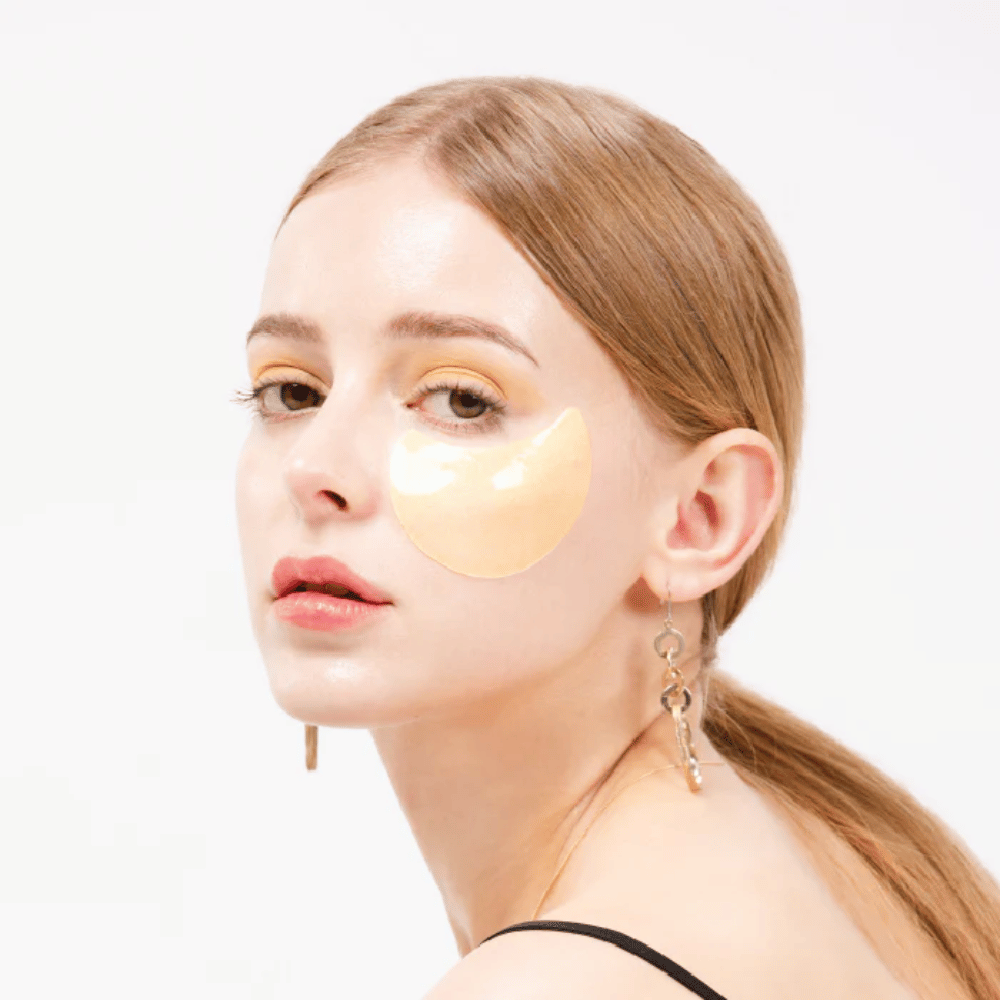 Modelo lleva un parche de hidrogel dorado bajo el ojo para un efecto iluminador.