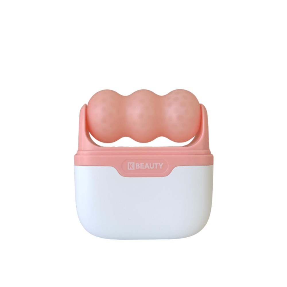 La imagen muestra un K-Beauty Ice Roller con un mango blanco y rosa. El producto tiene tres rodillos redondeados y punteados en color rosa en la parte superior, diseñado para enfriar y masajear el rostro. El fondo es completamente blanco.