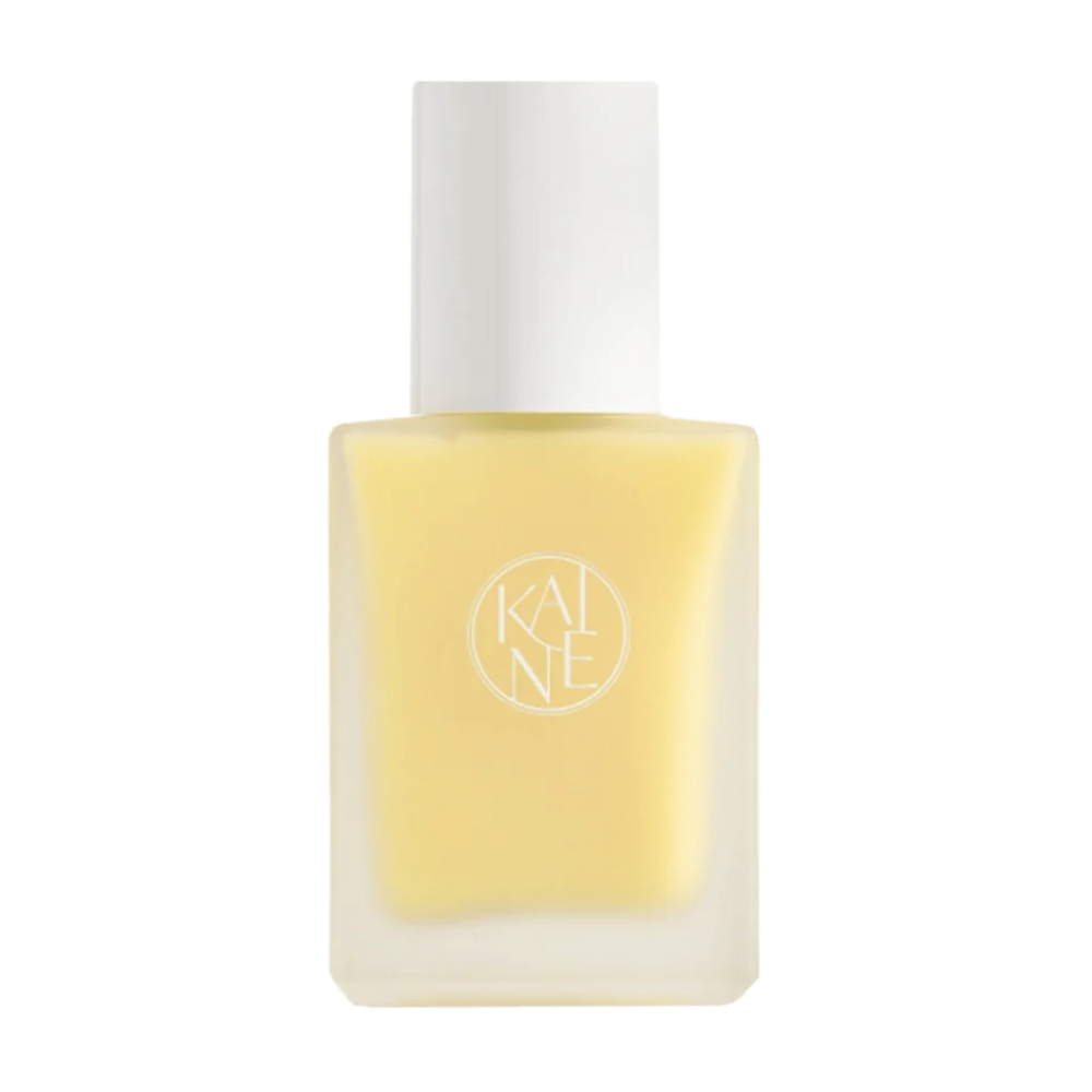 Una botella amarilla Vita Drop Serum de 30 ml sobre un fondo blanco con productos de cuidado de la piel KAINE.