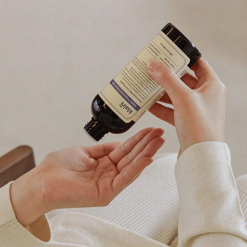 Una persona sostiene una botella de Klairs Supple Preparation Facial Toner boca abajo sobre su mano, lista para dosificar el producto.