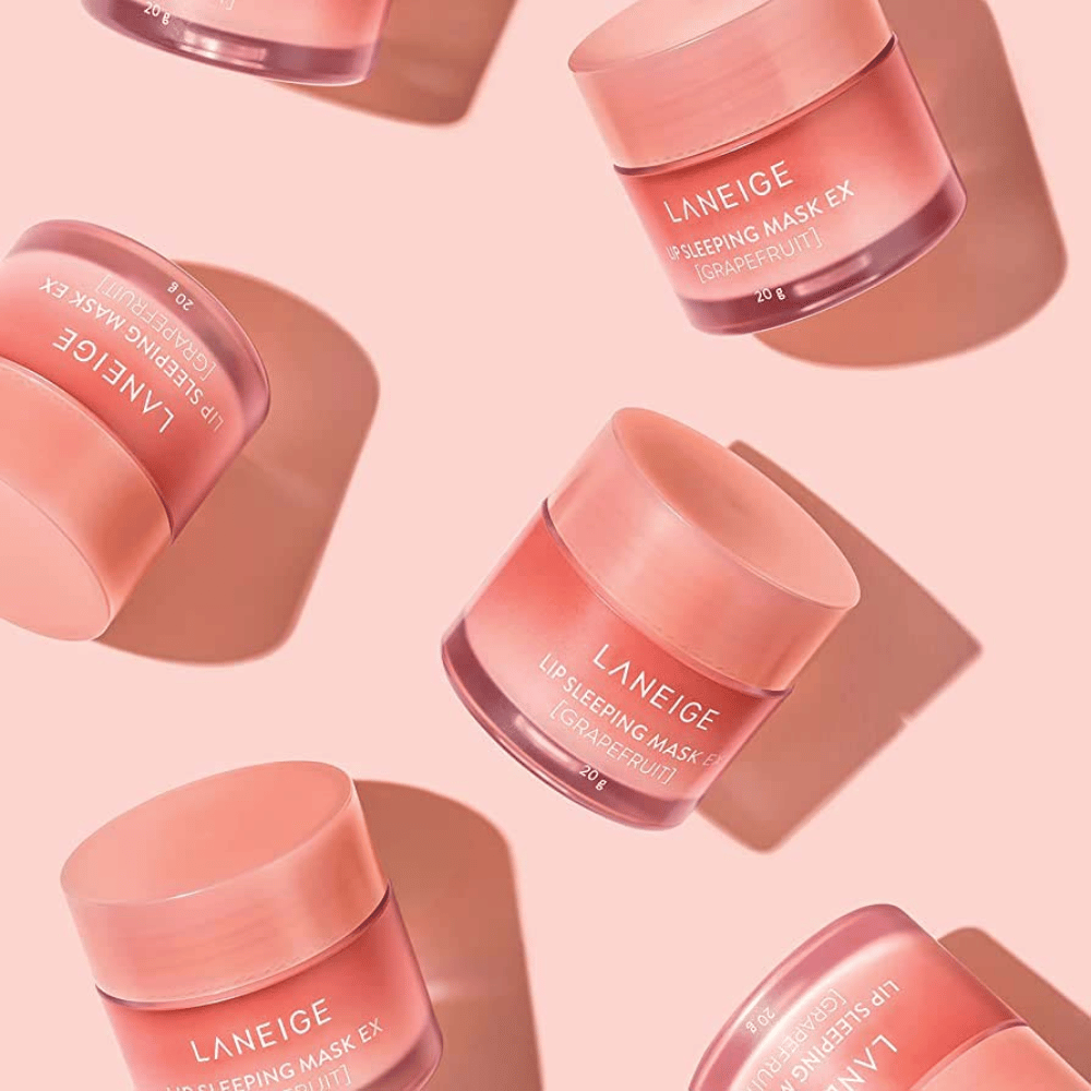 Cuatro latas LANEIGE Lip Sleeping Mask Pomelo 20g sobre fondo rosa, promueve pomelo e hidratación.