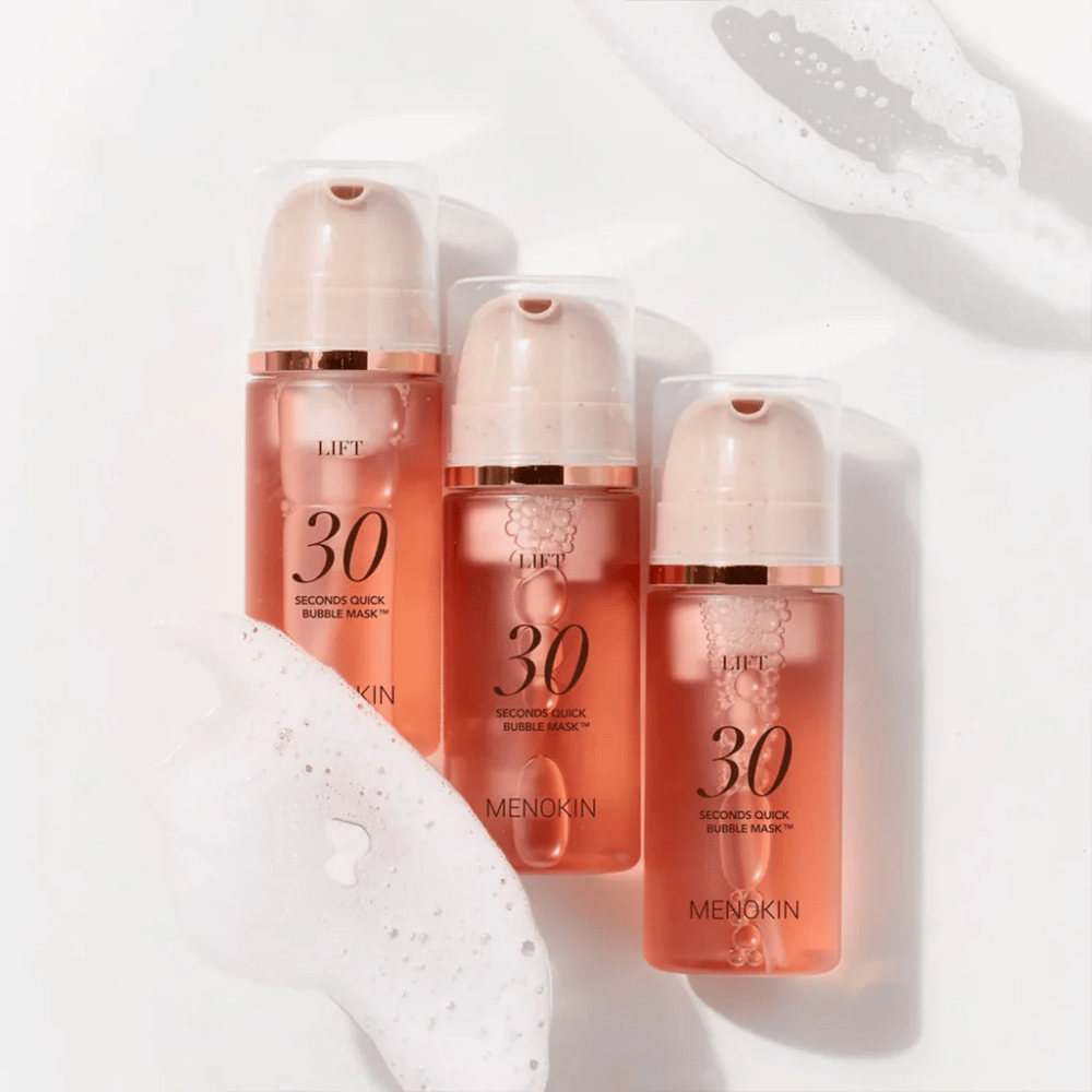 Imagen estética de producto con tres botellas de MENOKIN LIFT 30 Seconds Quick Bubble Mask rodeadas de espuma suave que resalta el efecto burbujeante y limpiador.