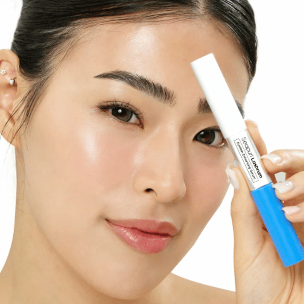 Mujer sostiene Seapuri Lashrum Eyelash Enhancing Serum. Un suero para pestañas que cuida, fortalece y define las pestañas.