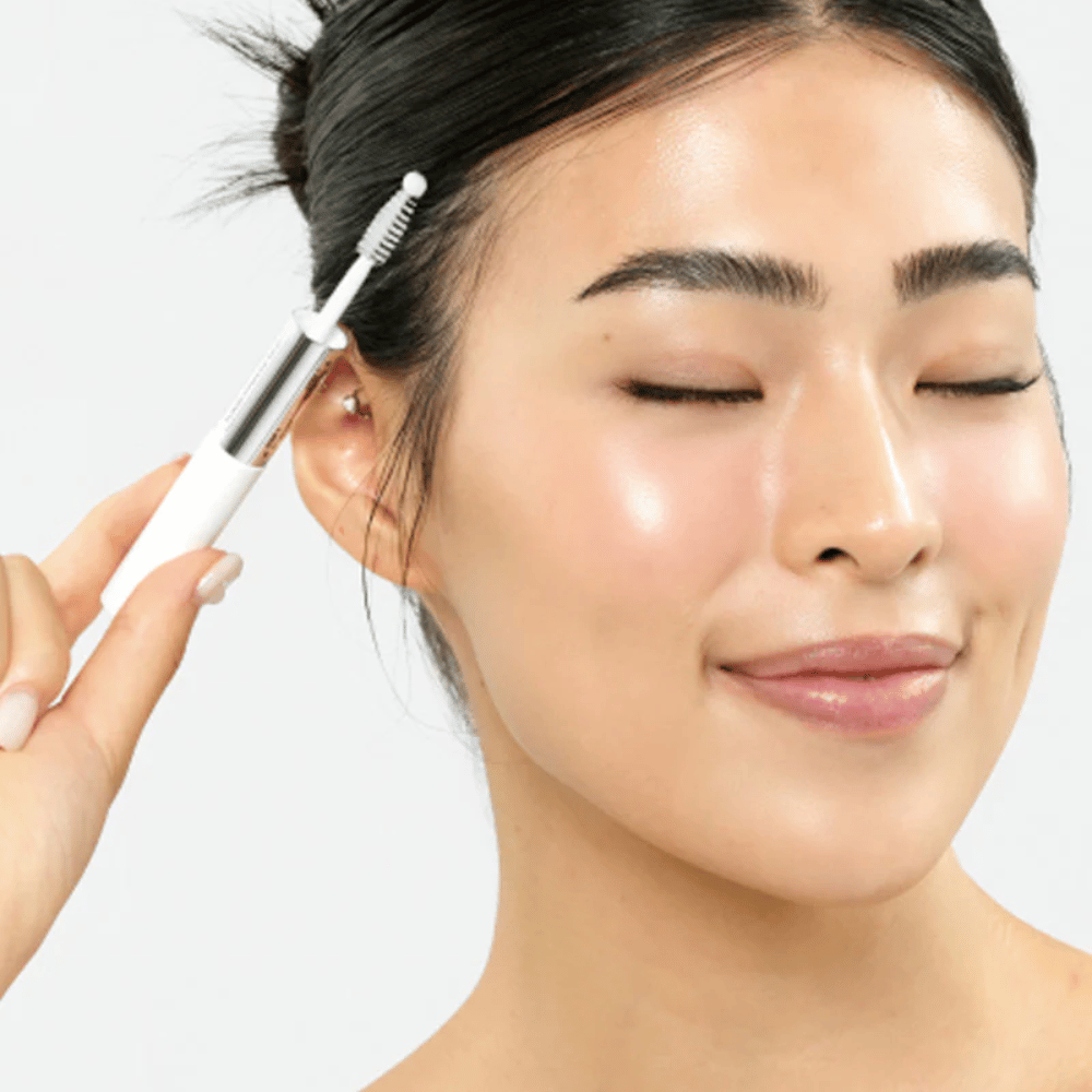 Mujer aplica Seapuri Lashrum Eyelash Enhancing Serum en las pestañas. Promueve el crecimiento natural y el brillo.