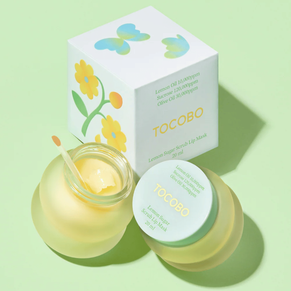 Tocobo Lemon Sugar Scrub Lip Mask junto con su empaque con diseño de flores sobre un fondo verde claro.