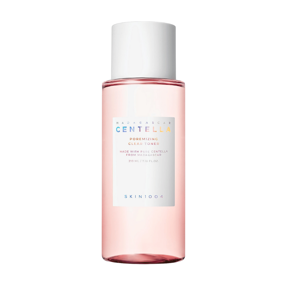 Una botella con Madagascar Centella Poremizing Clear Toner, que es transparente con un tono rosa. El producto tiene un tapón y etiqueta blancos con el texto "Poremizing Clear Toner" y "Hecho con Centella Pura de Madagascar." La botella contiene 210 ml y ofrece una sensación de frescura y cuidado de la piel.