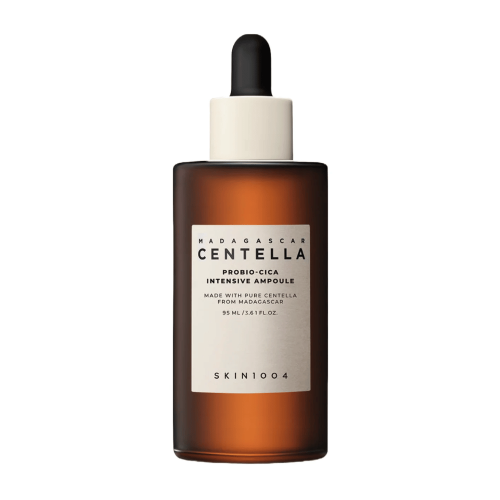 Botella de vidrio marrón con cuentagotas de SKIN1004 Madagascar Centella Probio-Cica Ampolla Intensiva contra un fondo de color sólido.