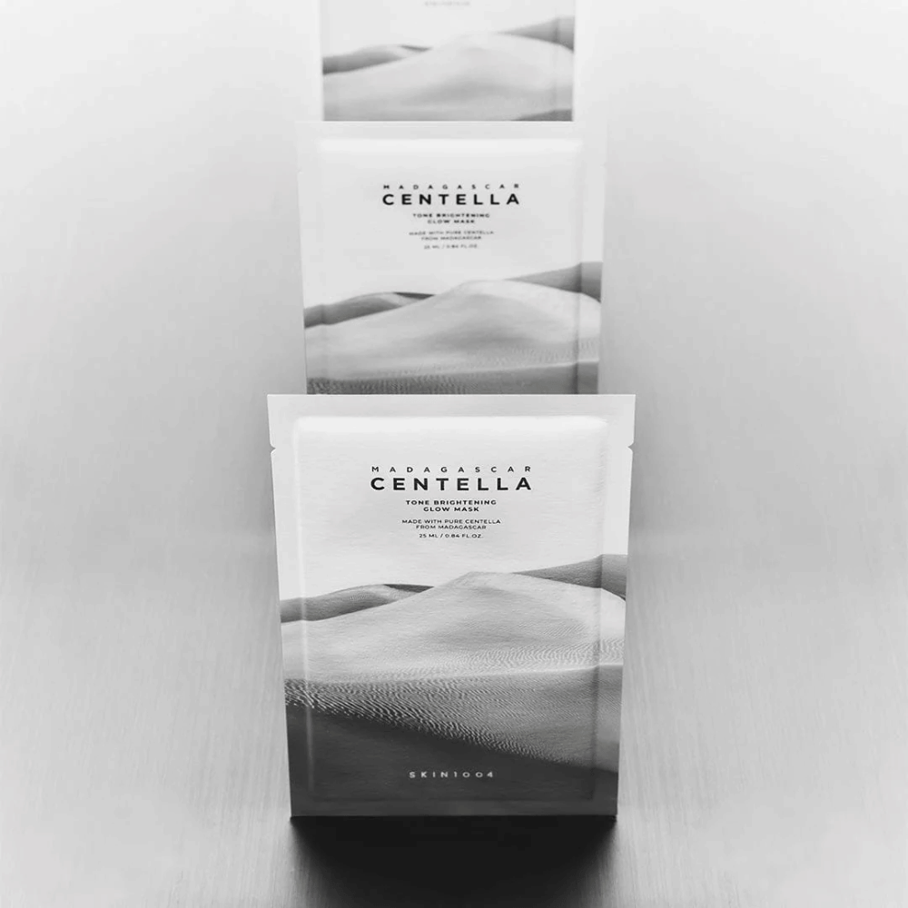 Varias mascarillas apiladas en fila, presentación de producto elegante en blanco y negro.