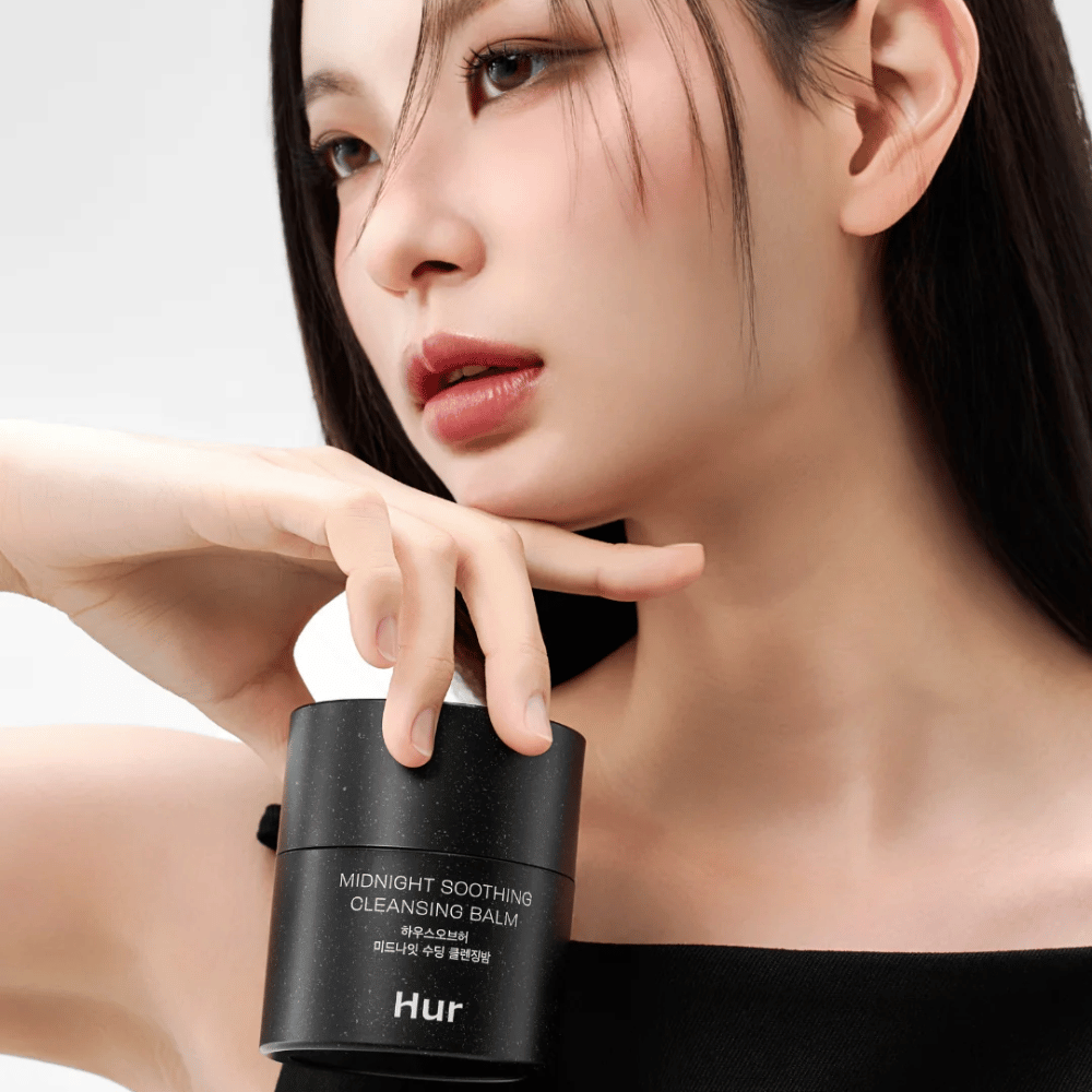 Modelo sostiene Cómo Midnight Soothing Cleansing Balm. Bálsamo limpiador coreano que elimina eficazmente el maquillaje y limpia la piel sin irritación.