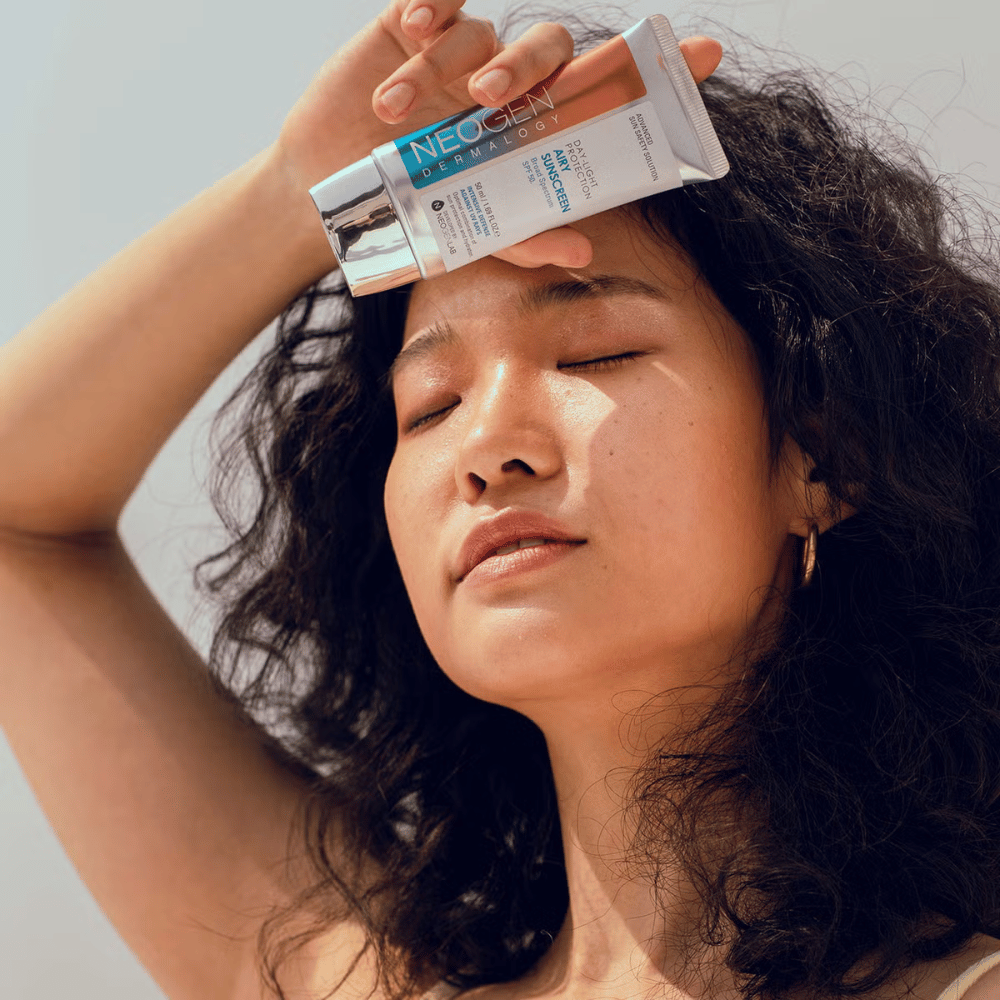Neogen Dermalogy Day-Light Protection Airy Sunscreen SPF50 50ml – crema solar ligera con protección UV de amplio espectro, mostrada en uso bajo la luz solar.