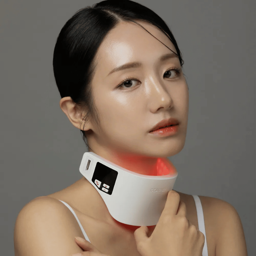 Modelo usando Beaund Neckcera alrededor del cuello. La iluminación LED roja ilustra el tratamiento activo mientras el dispositivo se adapta cómodamente a la piel.