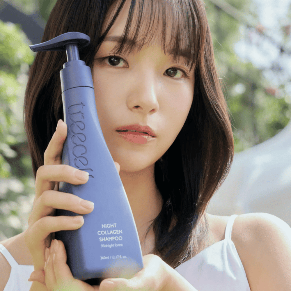 Mujer sosteniendo Treecell Night Collagen Shampoo Midnight Forest en un entorno natural. La imagen transmite cabello saludable, brillo y una sensación premium, con enfoque en el cuidado del cabello y del cuero cabelludo.