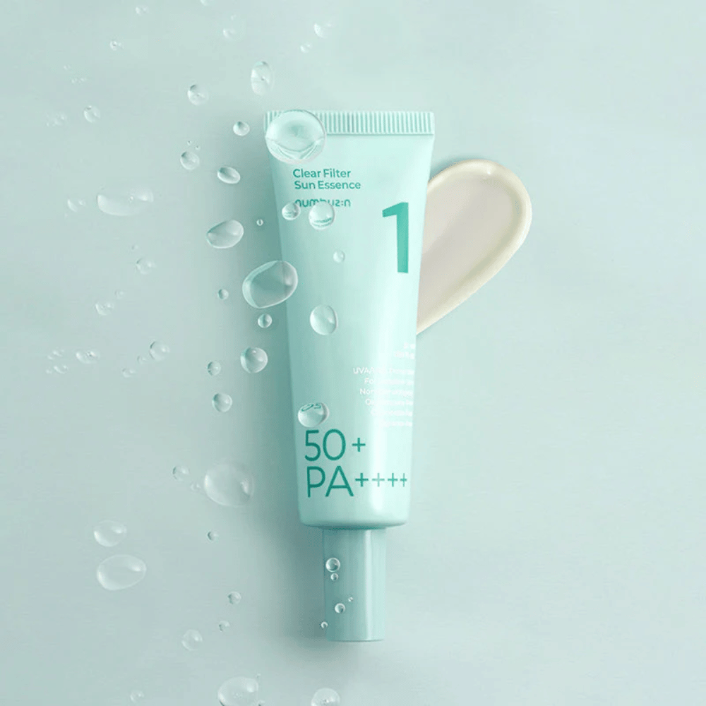 Un tubo azul claro con No.1 Clear Filter Sun Essence SPF 50+ PA++++. El tubo está decorado con gotas de agua y una muestra del producto se muestra al lado. El producto está diseñado para proporcionar un alto factor de protección solar y protección contra los rayos UVA/UVB.