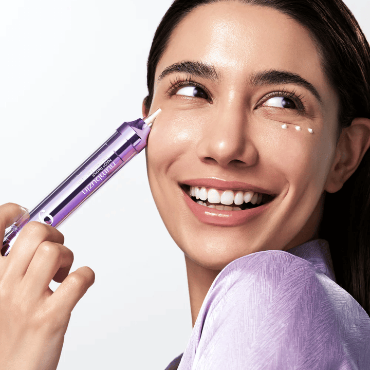 Modelo aplicando No.9 NAD+ Retinol Volumetox Eye Cream alrededor de los ojos con aplicador de precisión, para un cuidado dirigido contra las ojeras y líneas finas.