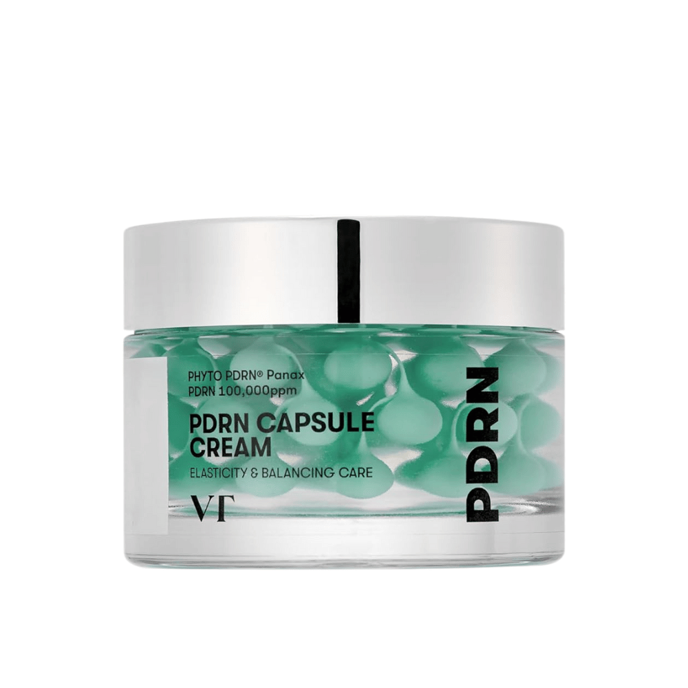VT PDRN Capsule Cream en un frasco transparente con tapa plateada. El contenido consiste en cápsulas verdes en un gel claro, y la etiqueta indica que la crema está destinada para elasticidad y cuidado equilibrante de la piel.