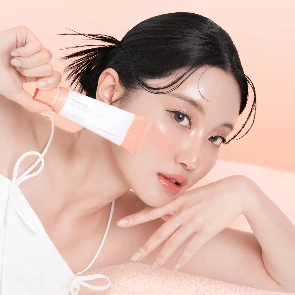 Persona con piel radiante sostiene Mixsoon PDRN Collagen Cream cerca de la mejilla. La crema hidrata, fortalece la elasticidad y proporciona un brillo saludable.