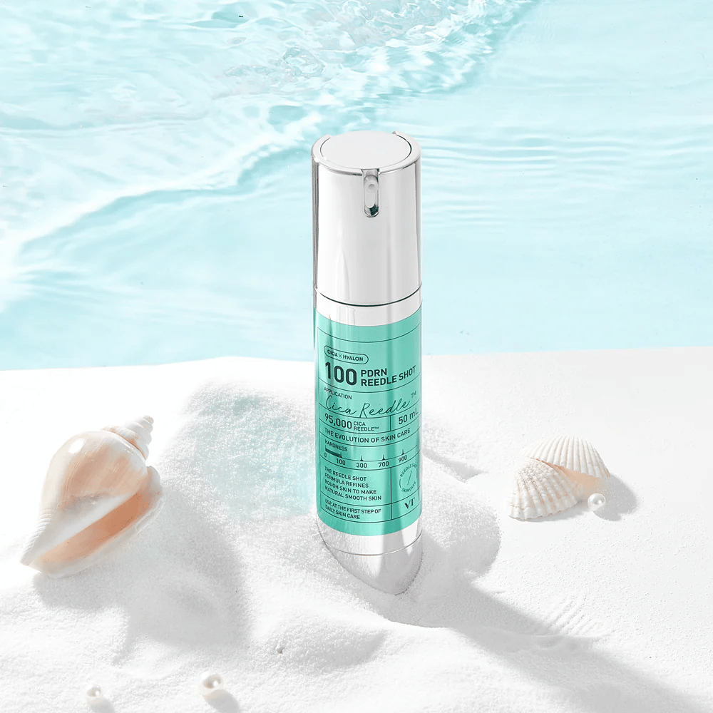 VT Cosmetics PDRN Reedle Shot 100 producto colocado en un entorno de arena con tema marino que simboliza hidratación, efecto calmante y mejora de la piel