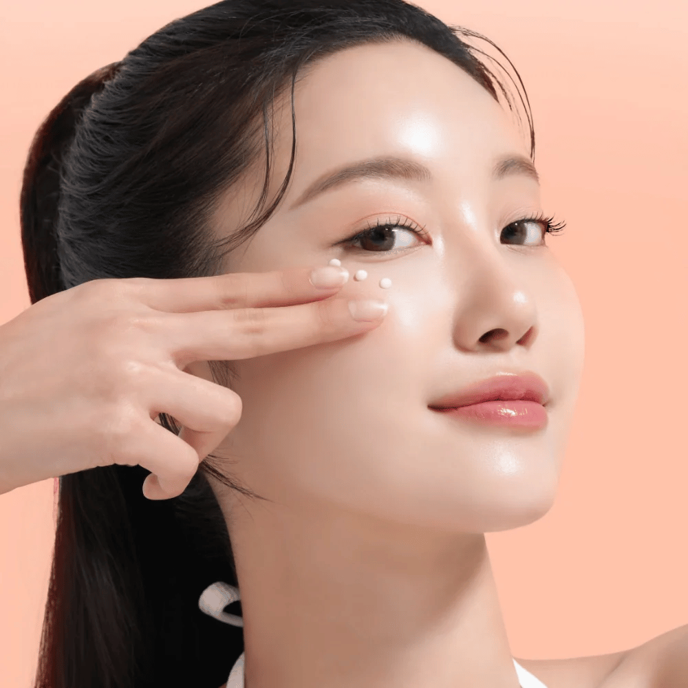 Persona aplica Mixsoon PDRN Collagen Eye Serum debajo de los ojos. El suero ilumina, reduce la hinchazón y fortalece la firmeza de la piel.