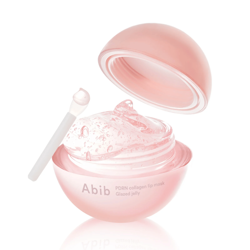 Rosa lata redonda con Abib PDRN Collagen Lip Mask Glazed Jelly, abierta con la tapa inclinada hacia atrás. Gel transparente con burbujas de aire visible en la lata junto con una pequeña espátula.