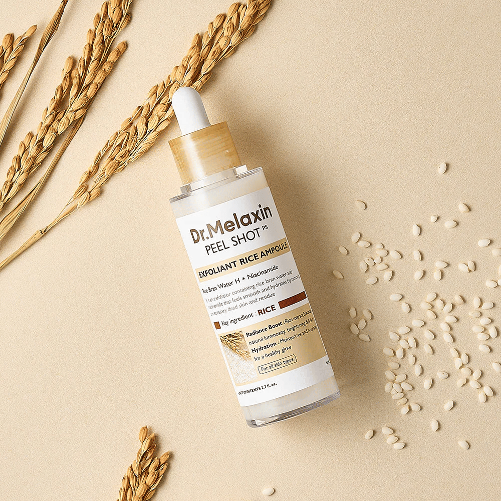Dr.Melaxin Peel Shot Rice Ampoule tumbado sobre una superficie color arena con arroz y espigas, ampolla facial exfoliante que combina ácidos suaves con hidratación intensa.