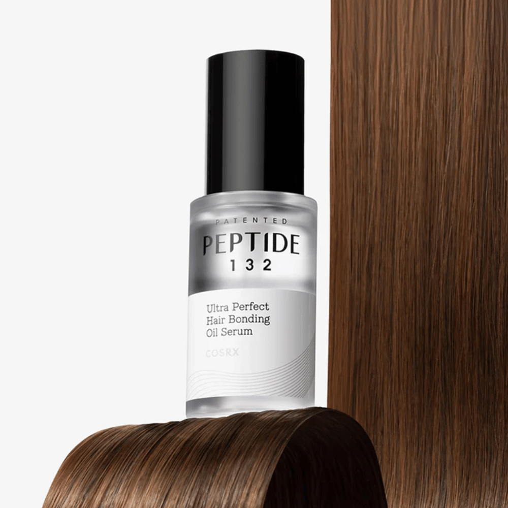 COSRX Peptide 132 Ultra Perfect Hair Bonding Oil Serum colocado contra cabello brillante – proporciona fuerza, suavidad y brillo.
