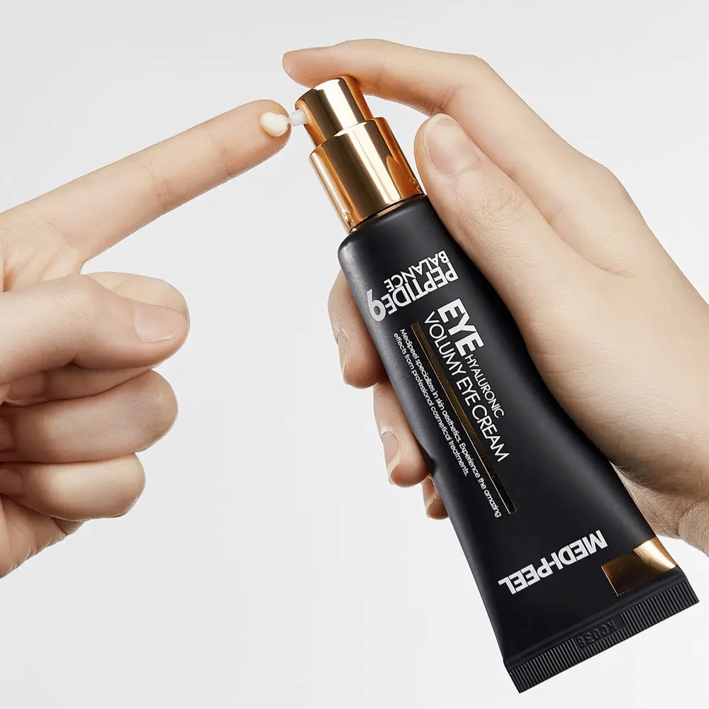 Aplicación de MEDI-PEEL Peptide 9 Hyaluronic Volumy Eye Cream en la yema del dedo – hidratante contorno de ojos con complejo de péptidos que ayuda a reducir las líneas finas y proporciona una piel más rellena.