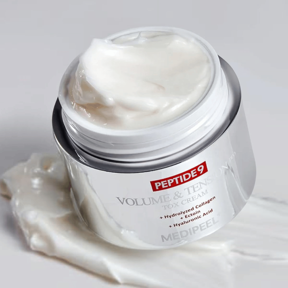 Primer plano de MEDI-PEEL Peptide 9 Volume & Tension Tox Cream. La rica crema contiene colágeno hidrolizado, ectoína y ácido hialurónico para una piel más firme e hidratada.