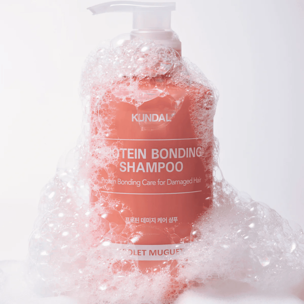 KUNDAL Protein Bonding Shampoo Violet Muguet cubierto de espuma abundante, champú reparador para cabello dañado.
