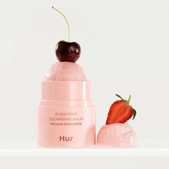 Abierto Cómo Purifying Cleansing Balm con textura similar a un sorbete decorado con cerezas y fresas. Bálsamo limpiador inspirado en frutas con propiedades suavizantes y limpiadoras.