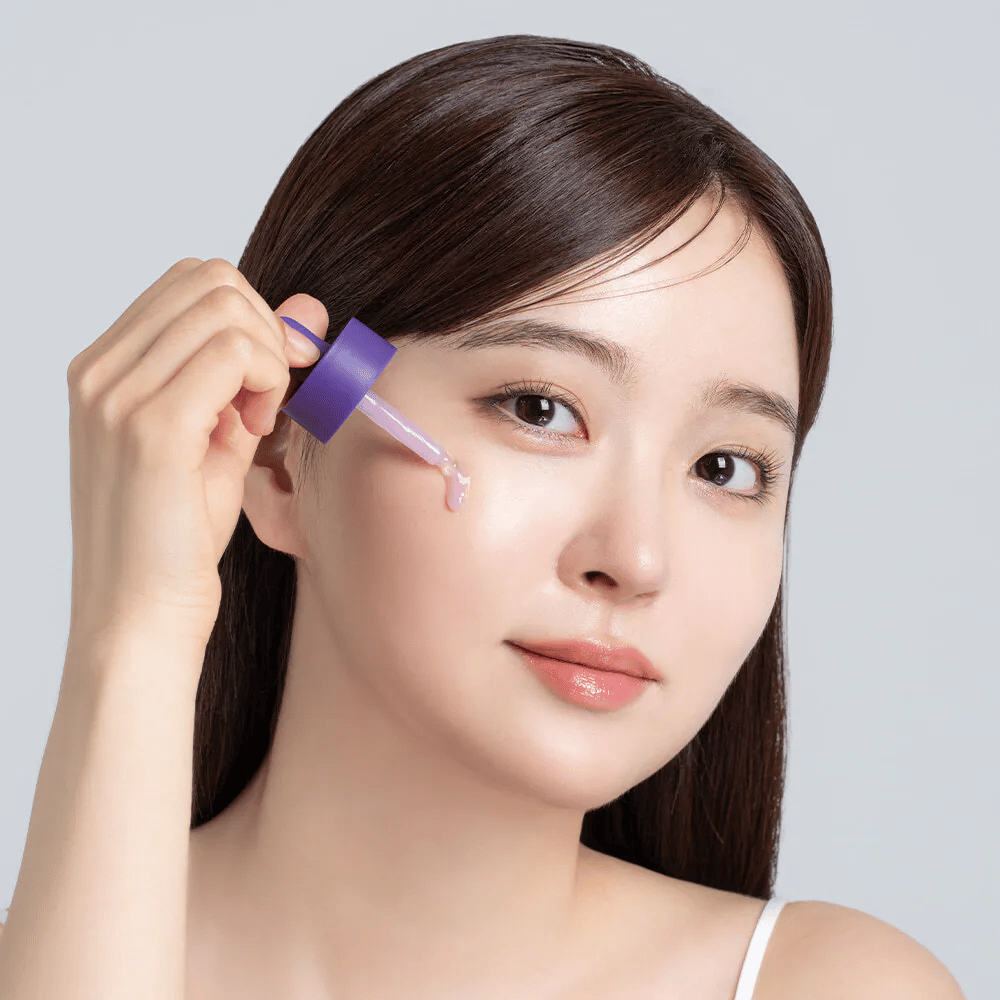 Aplicación de Cellology Purple Carrot Pore Ampoule con gotero en el rostro para el cuidado de los poros y una textura de piel más uniforme.