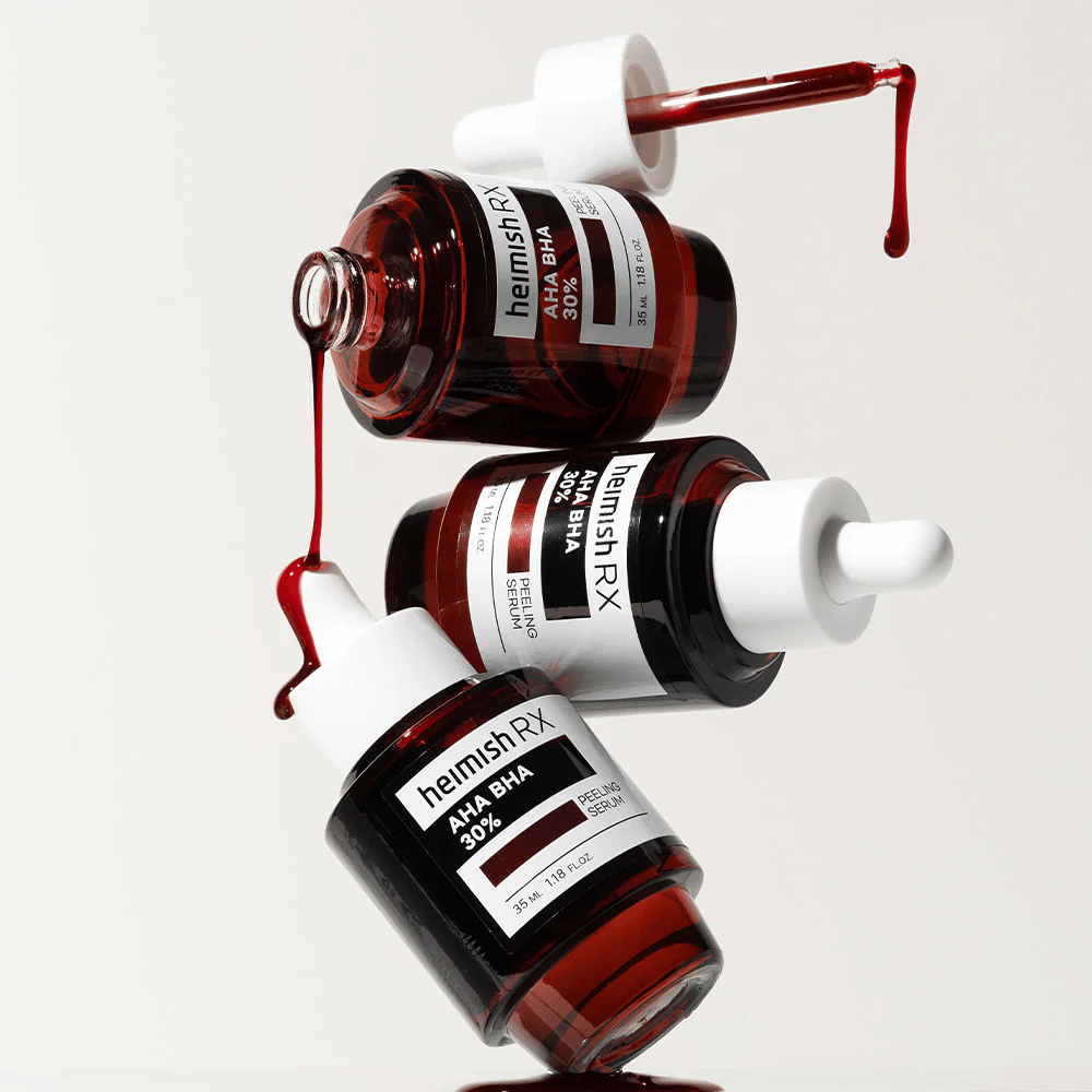 Tres frascos de Heimish RX AHA BHA 30% Peeling Serum en una composición dinámica, con suero de color rojo goteando de las pipetas.