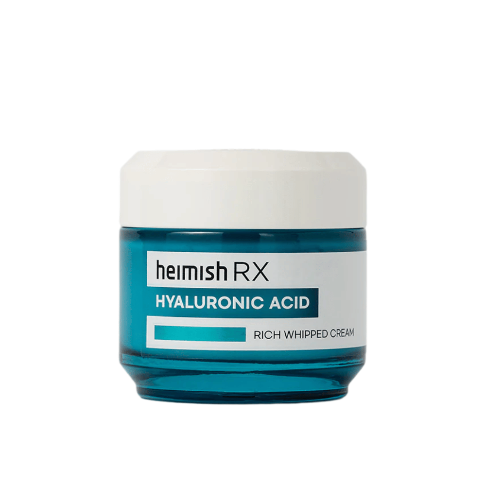 Heimish RX Hyaluronic Acid Rich Whipped Cream en un tarro de vidrio azul elegante con tapa blanca. Una crema facial nutritiva con ácido hialurónico para una hidratación intensa y piel suave y rellena.