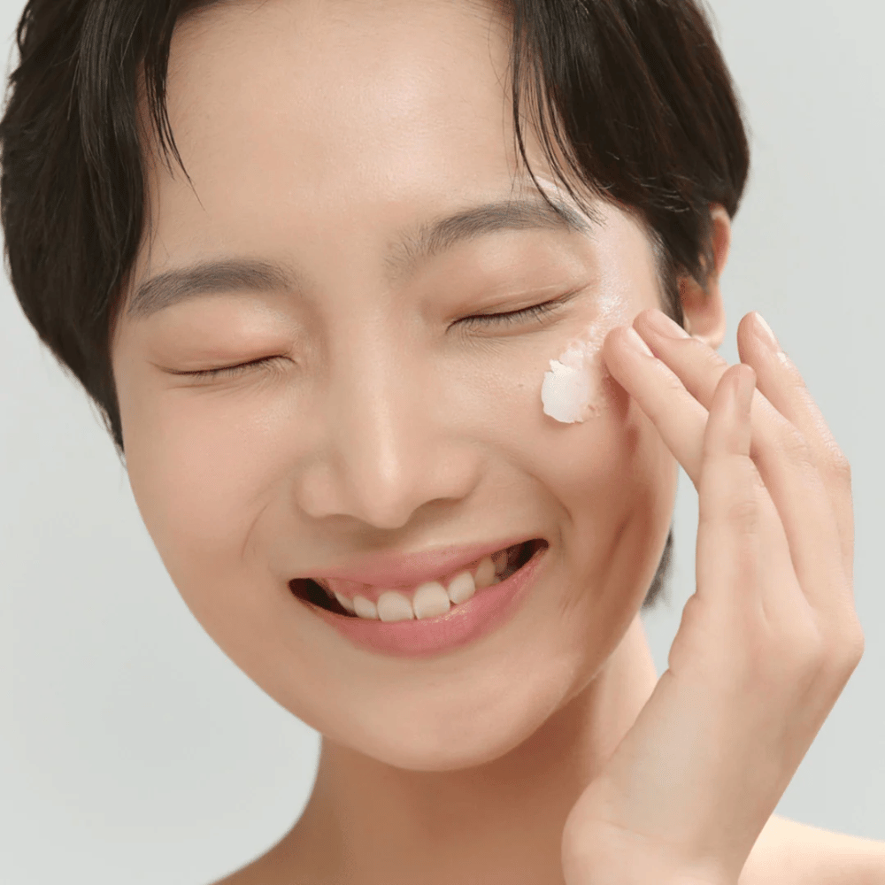 Modelo con piel luminosa aplicando Beauty of Joseon Radiance Cleansing Balm – bálsamo limpiador coreano que derrite el maquillaje e impurezas.