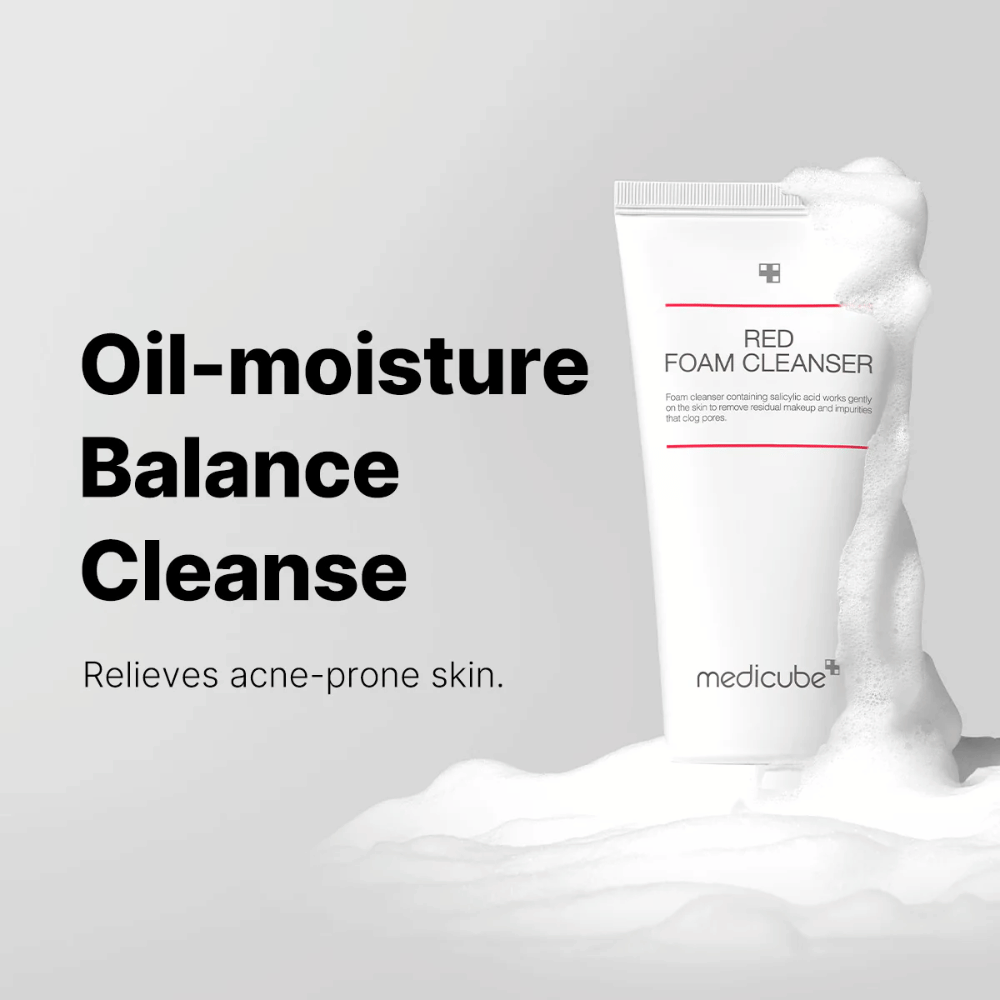 Tubo con Medicube Red Foam Cleanser de pie entre espuma burbujeante. El texto "Oil-moisture Balance Cleanse" se muestra a la izquierda, con la descripción "Relieves acne-prone skin" debajo. El fondo es gris claro.