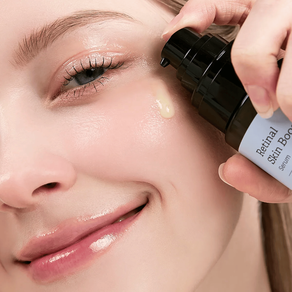 Persona aplica Meditherapy Retinal Skin Booster Serum cerca del ojo. El suero tiene un tono ligero y amarillo, y proporciona a la piel brillo y firmeza.