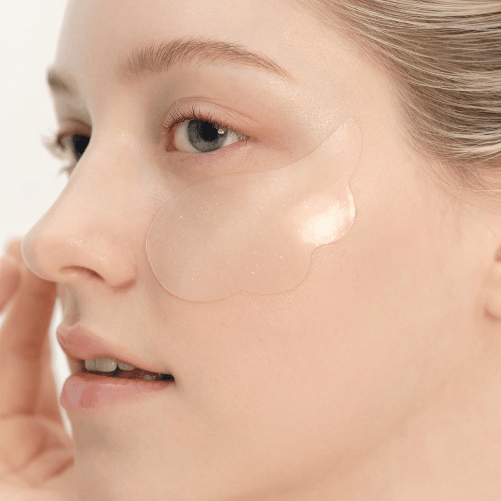 Primer plano de modelo aplicando Beauty of Joseon parche para ojos debajo del ojo para hidratación, brillo y efecto reafirmante.