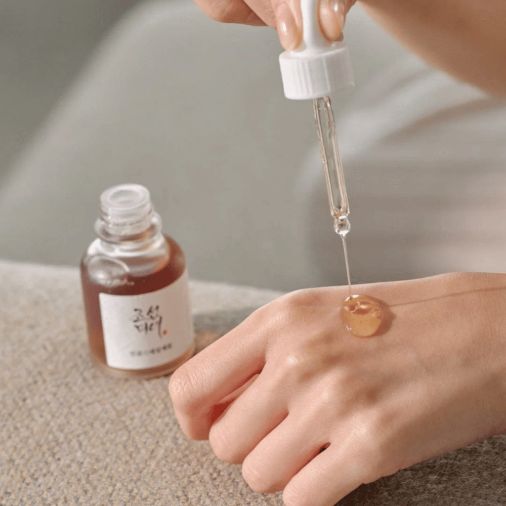 El gotero aplica Beauty of Joseon Revive Serum Ginseng + mucina de caracol sobre la piel – suero coreano para elasticidad e hidratación.