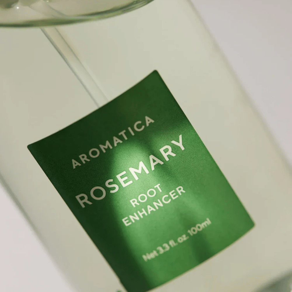 Imagen detallada de la etiqueta de AROMATICA Rosemary Root Enhancer. La etiqueta verde y la botella transparente resaltan el aspecto limpio y minimalista del producto.