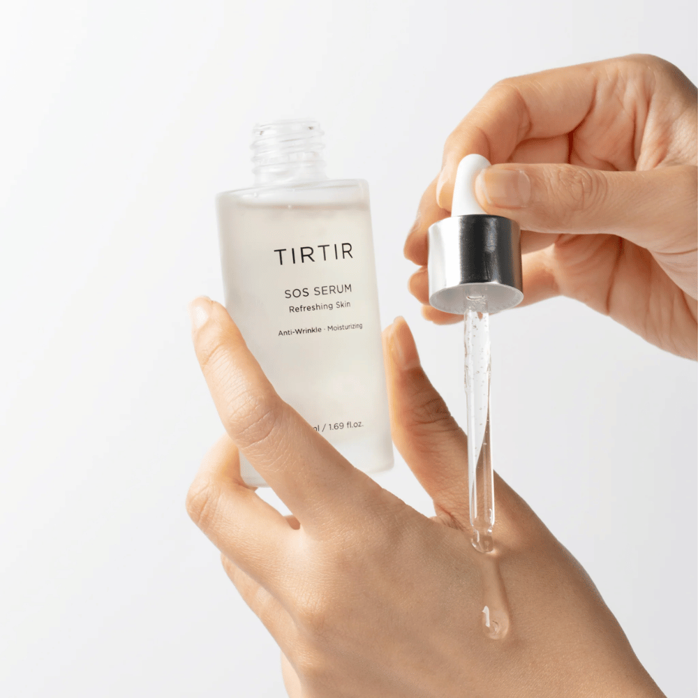 Manos que gotean TIRTIR SOS Serum de una pipeta, destinada para el cuidado de la piel.