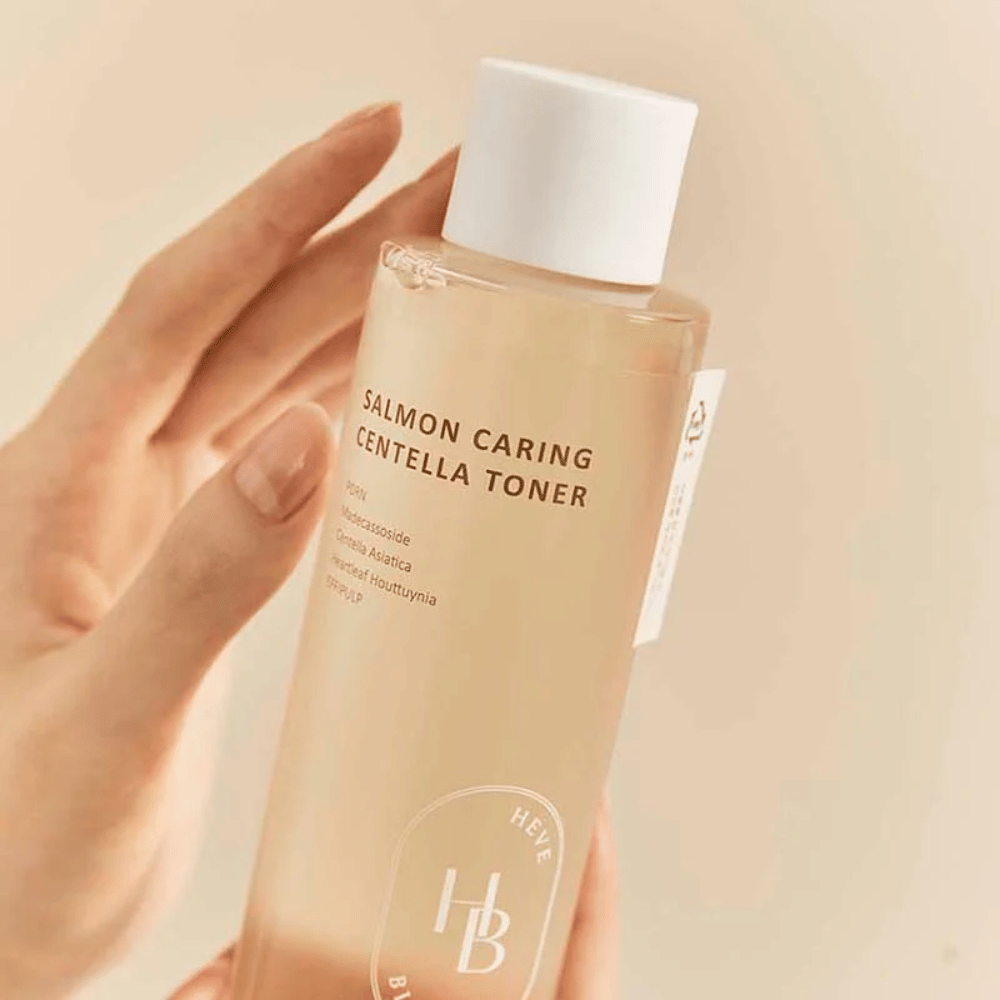 Primer plano de Salmon Caring Centella Toner en mano – tónico calmante con PDRN y extracto de plantas que ayuda a fortalecer la piel y reducir la sensación de irritación.