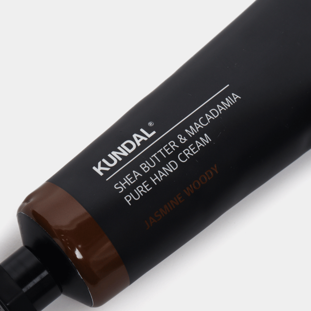Primer plano de KUNDAL Shea Butter & Macadamia Pure Hand Cream Jasmine Woody que muestra el elegante empaque y la sensación premium de la crema de manos.