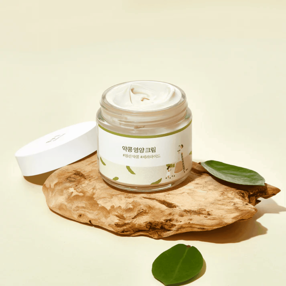 Mixsoon Soybean Nourishing Cream en un frasco abierto sobre una pieza de madera con hojas verdes. Una crema nutritiva con soja fermentada y ceramidas.