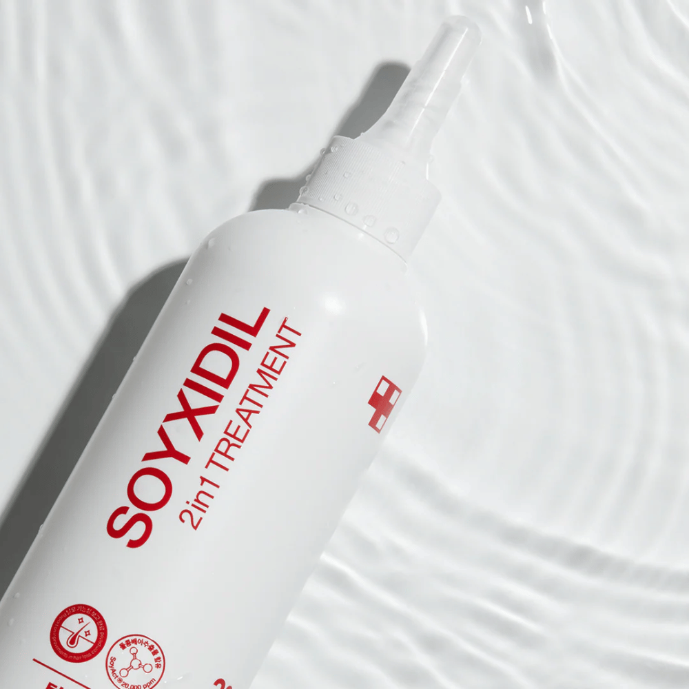 Botella de Medicube Soyxidil 2in1 Treatment se encuentra sobre una superficie de agua ondulada, simbolizando cuidado hidratante y refrescante.