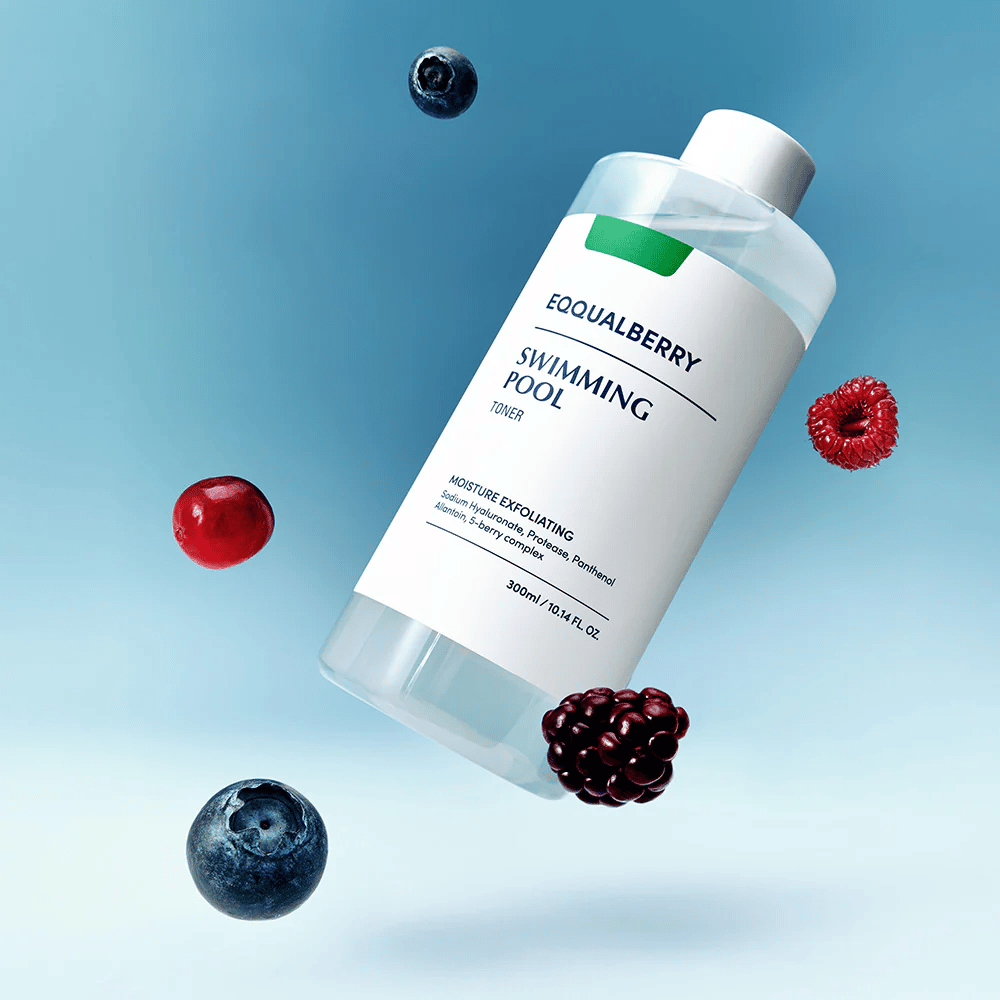 Equalberry Swimming Pool Toner en una botella elegante flotando contra un fondo azul, rodeada de bayas frescas como arándanos, frambuesas y moras.