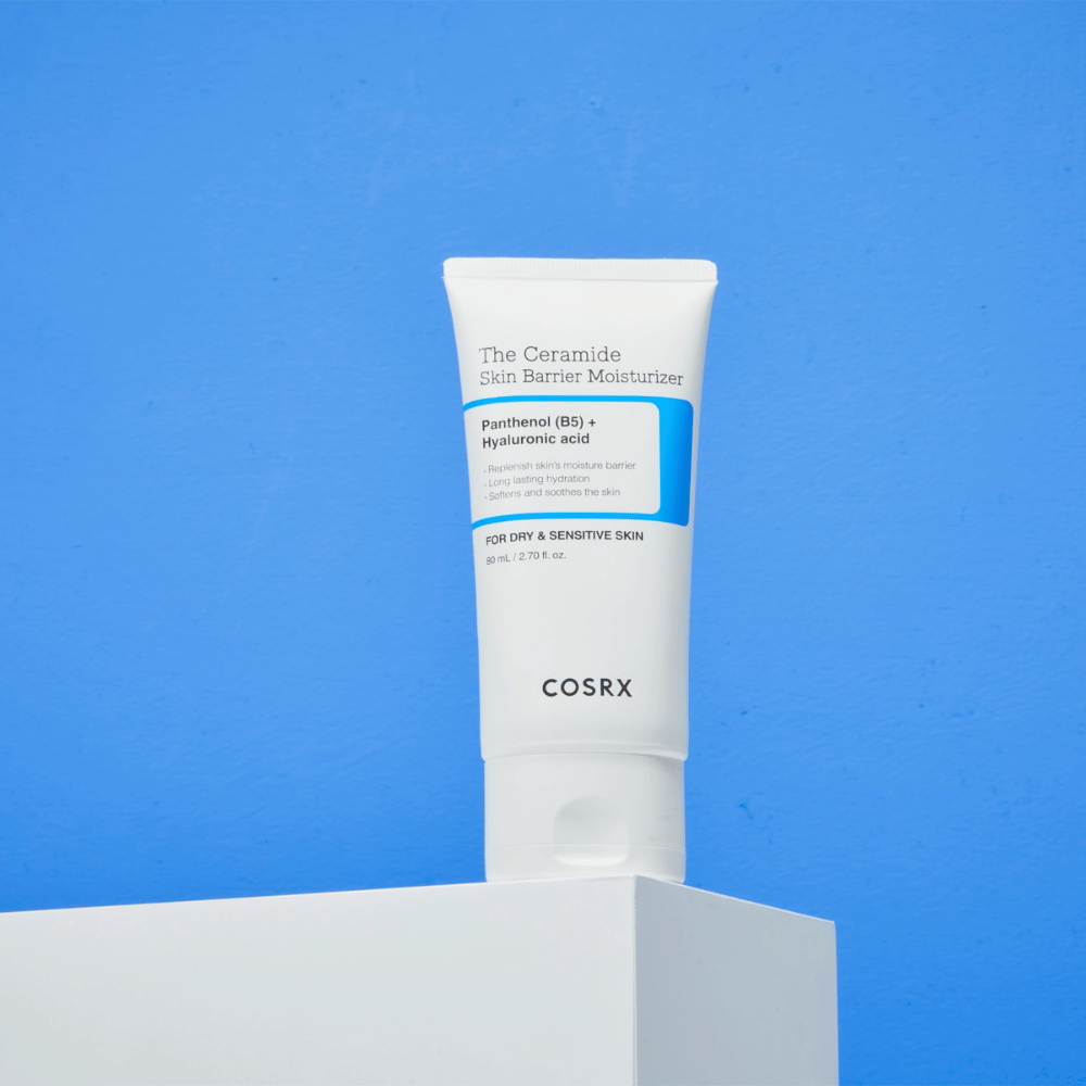 COSRX The Ceramide Skin Barrier Moisturizer sobre pedestal - crema facial hidratante con ceramidas, pantenol y ácido hialurónico para piel seca y sensible.